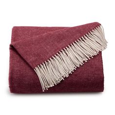 a red and white blanket with fringes on the edges, folded in two rows