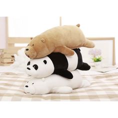 two stuffed panda bears sitting on top of each other in the middle of a bed