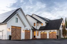 a white house with brown garage doors and windows