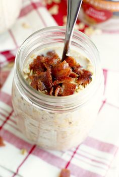 a jar filled with oatmeal sitting on top of a red and white checkered table cloth