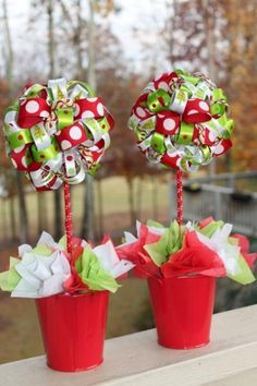 two red buckets filled with bows and candy canes sitting on top of a window sill