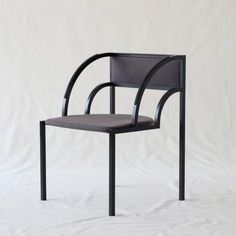 a black chair on a white background with no one in the room to see it