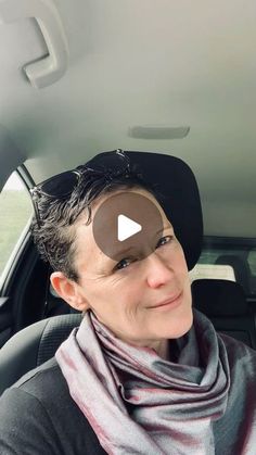 a woman sitting in the back seat of a car wearing a hat and scarf with an eye patch on her forehead