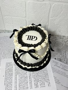 a three tiered cake sitting on top of a newspaper