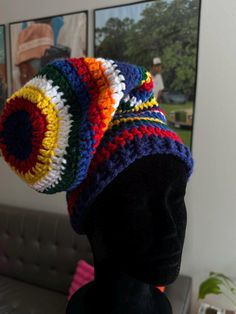 a crocheted multicolored hat sits on top of a mannequin head