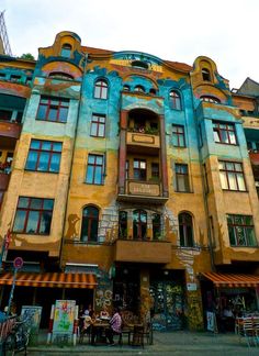 an old building with many windows and balconies on the top floor is painted in different colors