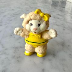 a yellow and white figurine on a table