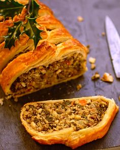 a piece of meat filled pastry next to a knife