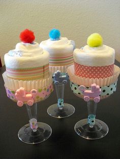 three decorated cupcakes sitting on top of each other in wine goblets