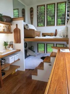 the interior of a tiny house with stairs leading up to it's loft bed