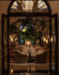 a living room filled with lots of furniture and plants in it's centerpiece