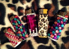 several different types of lighters are on a leopard print surface with beads and jewels