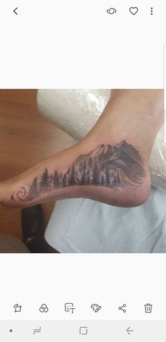 a person with a mountain tattoo on their foot and an arrow in the sky above them