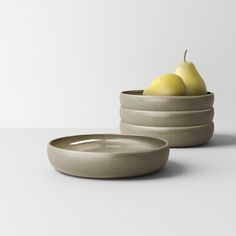 two bowls with pears in them on a table