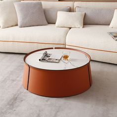 a living room with white couches and orange coffee table in the middle, on carpeted flooring