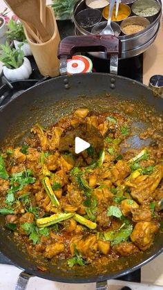 a wok filled with food on top of a stove