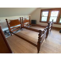 an empty bedroom with wood floors and wooden bed frames in the corner, looking down