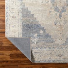 an area rug with wood flooring and wooden floors in the background, including a large blue