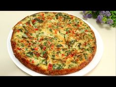 a pizza sitting on top of a white plate covered in cheese and veggies