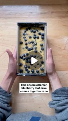 someone holding up a pan with blueberries in it