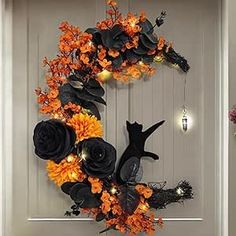 a halloween wreath with black cats and orange flowers