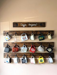 coffee mugs are hanging on a wall with the words coffee anyone?