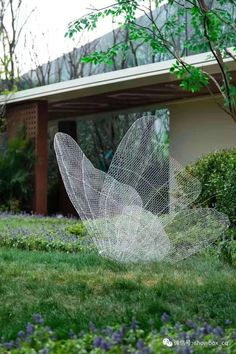 a wire sculpture in the middle of some grass