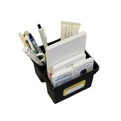 a black plastic container filled with lots of papers and office supplies on top of a white background