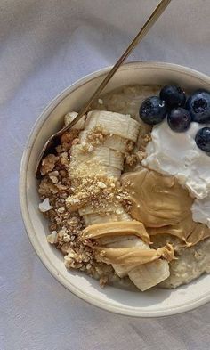 a bowl filled with oatmeal, bananas and blueberries