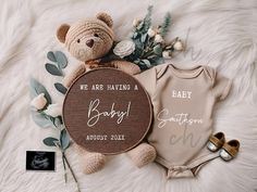 a teddy bear and some baby items are laying on a white furnishing next to each other