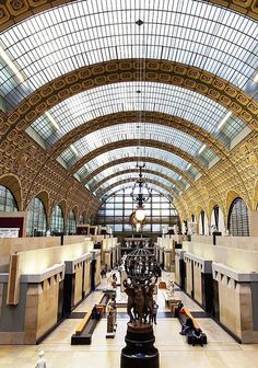 the inside of a train station with lots of benches and lights on it's ceiling