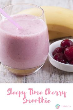 a smoothie in a glass next to a banana and cherries