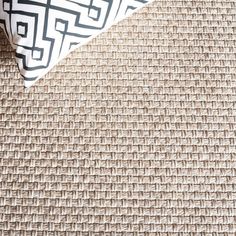 a close up view of a pillow on a chair with a black and white pattern