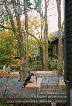 two people sitting on wooden benches in the woods