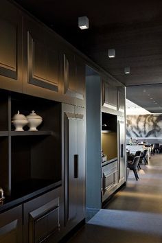 an empty dining room and kitchen area in a modern style home with dark wood paneling