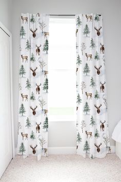 the curtains in this room are decorated with deer and pine trees