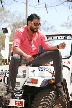 a man sitting on top of a white jeep