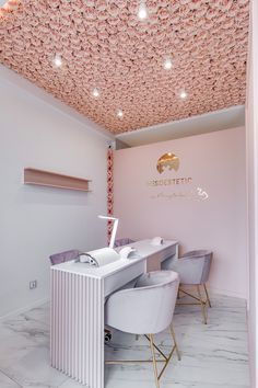 the interior of a nail salon with white chairs and pink walls, decorated with flowers