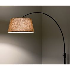 a lamp that is on the side of a wall next to a light fixture with a fabric shade