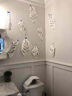 a white toilet sitting next to a bathroom sink under a mirror on top of a wall