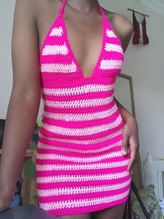 a woman in a pink and white crochet swimsuit posing for the camera