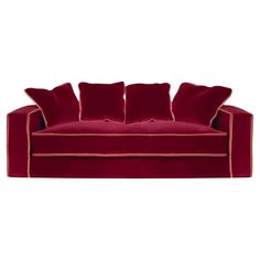 a red velvet couch with four pillows on it's back and two sides, facing the