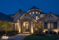 a house that is lit up at night with lights on the front and side windows