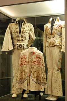 elvis presley's white outfits are on display in a glass case at the museum