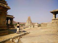 a woman standing in front of some stone structures