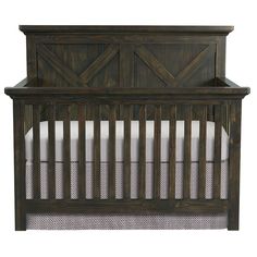 a wooden baby crib with white sheets on the bottom and side rails, against a white background