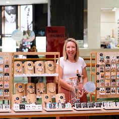 a woman standing in front of a table full of jewelry