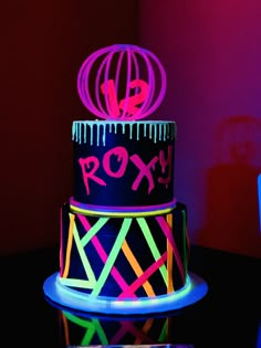 a three tiered cake with neon lights on it