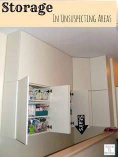 the inside of a kitchen with white cupboards and an arrow pointing to the storage area