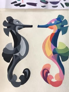 two seahorses painted on white paper next to each other with different colors and shapes